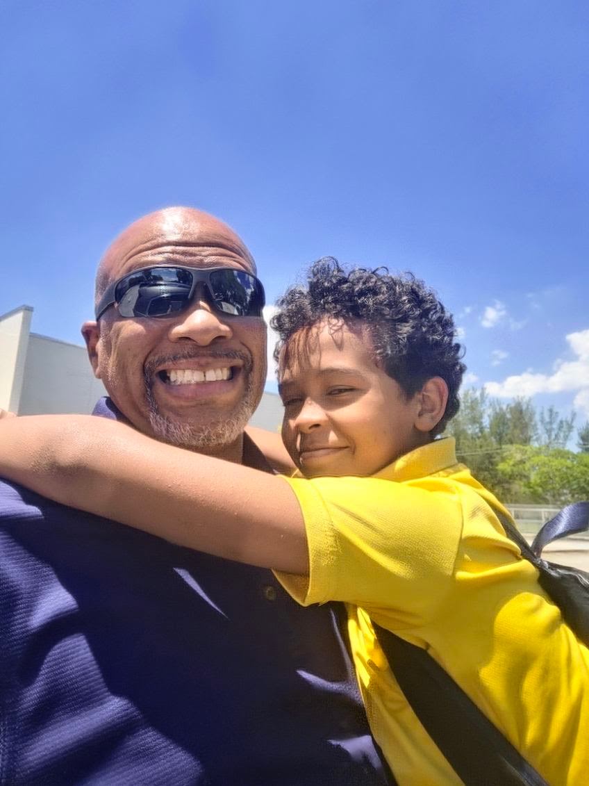 Dr. Jennings embracing a smiling student outdoors