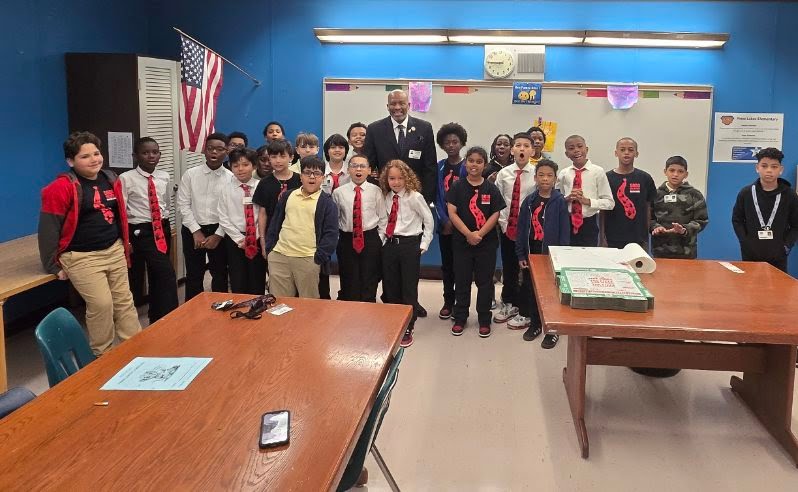 Dr. Jennings with a classroom of elementary students wearing red ties